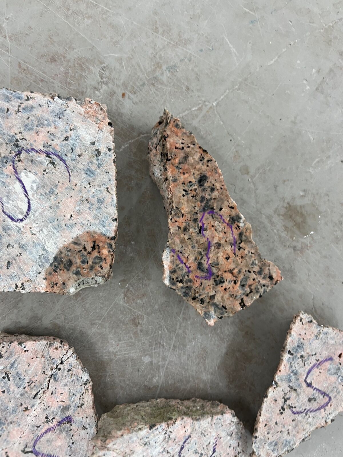 Foto av ulike steintyper liggende på et gulv.