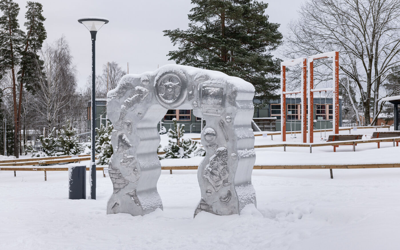 Foto av Morten Jensen Vågens skulptur Samfunnsportalen utendørs i en snødekt skolegård.