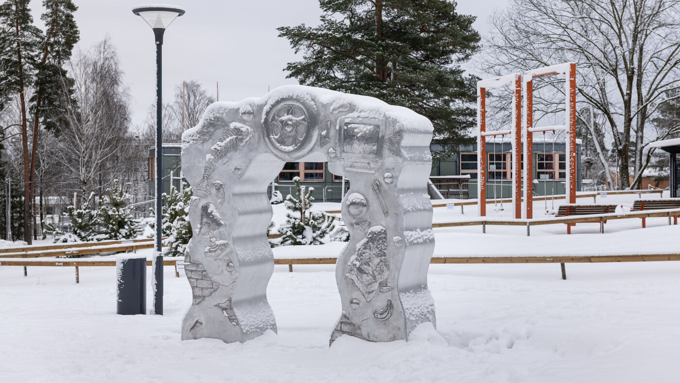 Foto av Morten Jensen Vågens skulptur Samfunnsportalen utendørs i en snødekt skolegård.