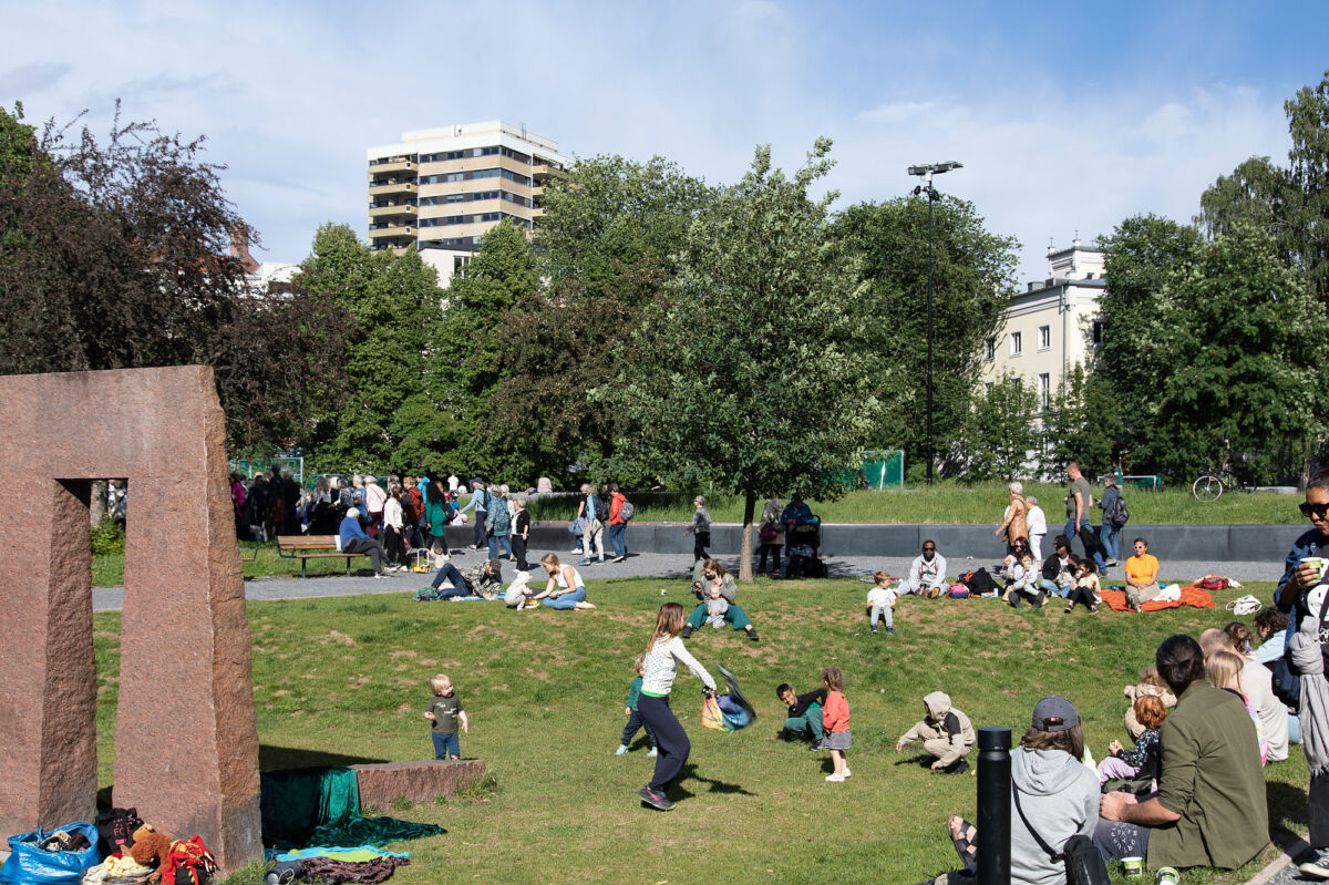 Foto av mennesker som sitter, leker og beveger seg på grøntområde i Klosterenga park.