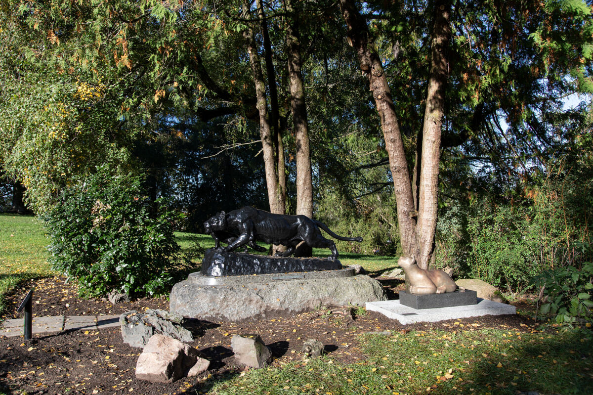 Foto av en skulptur med en løvinne og løveunge, ved siden av en annen skulptur av en løveunge.