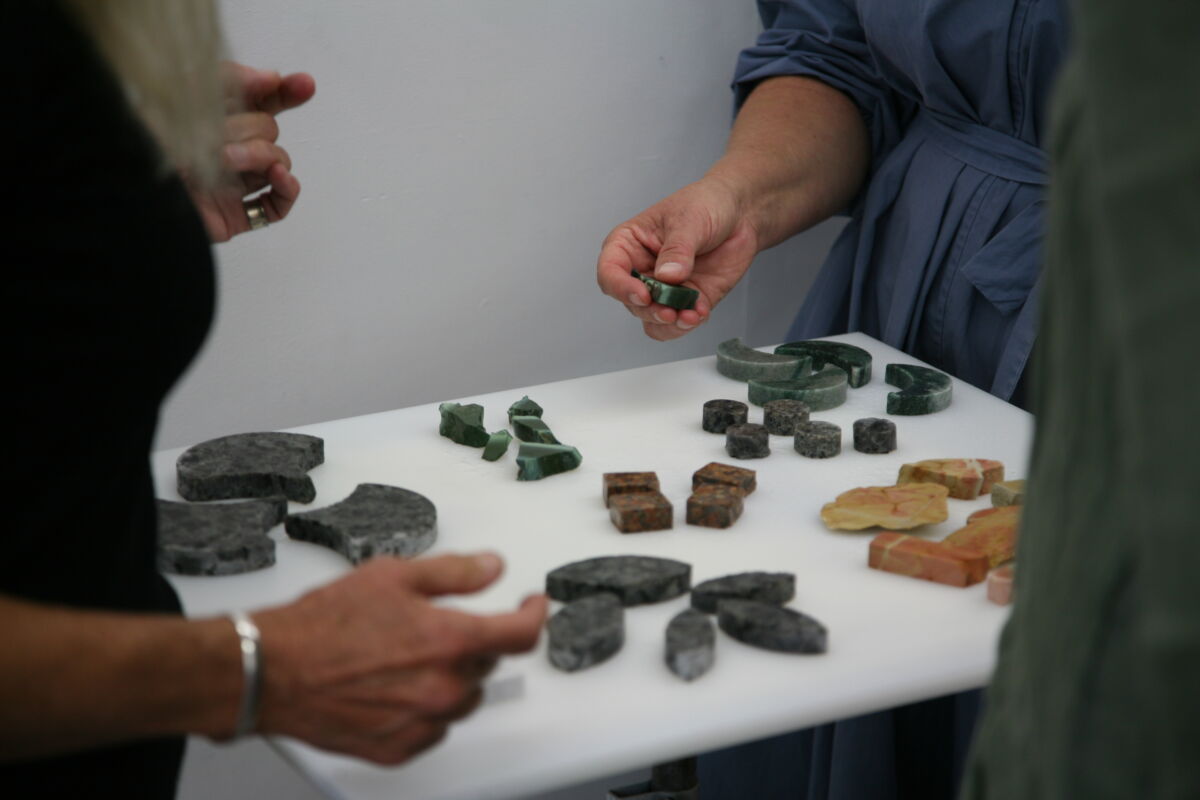 Foto av flere personer som står rundt et bord med ulike steintyper.