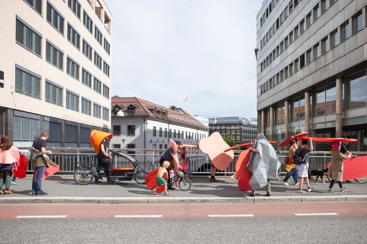 Foto av flere personer vandrende nedover en gate som del av et kunstprosjekt.